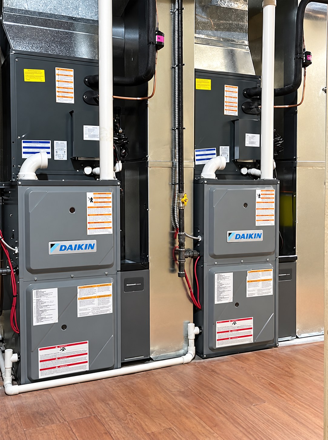 Two Daikin furnaces with connected ductwork and white piping